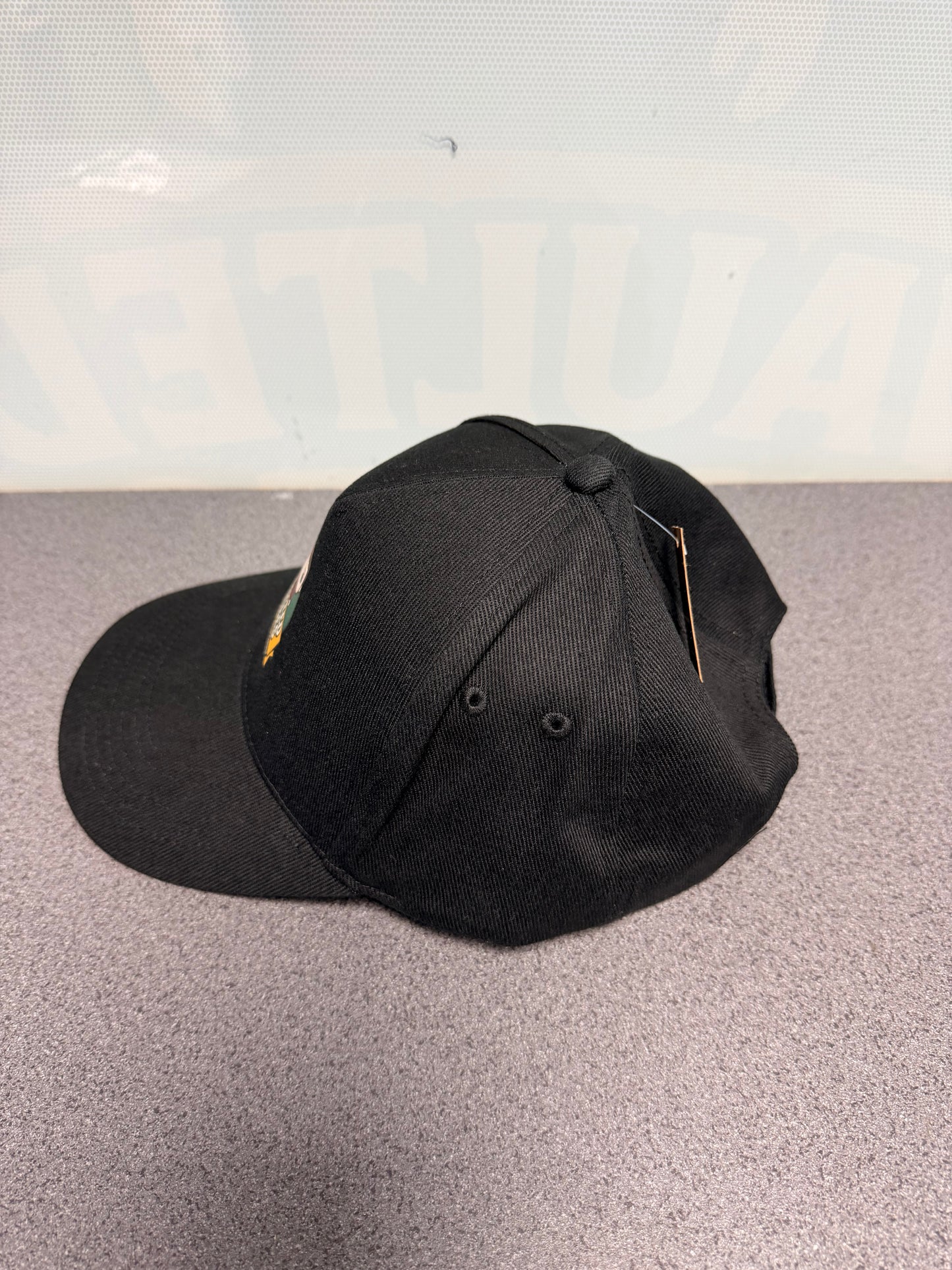 Black Vaulted Vibes baseball cap, side view showing curved peak and ventilation eyelets