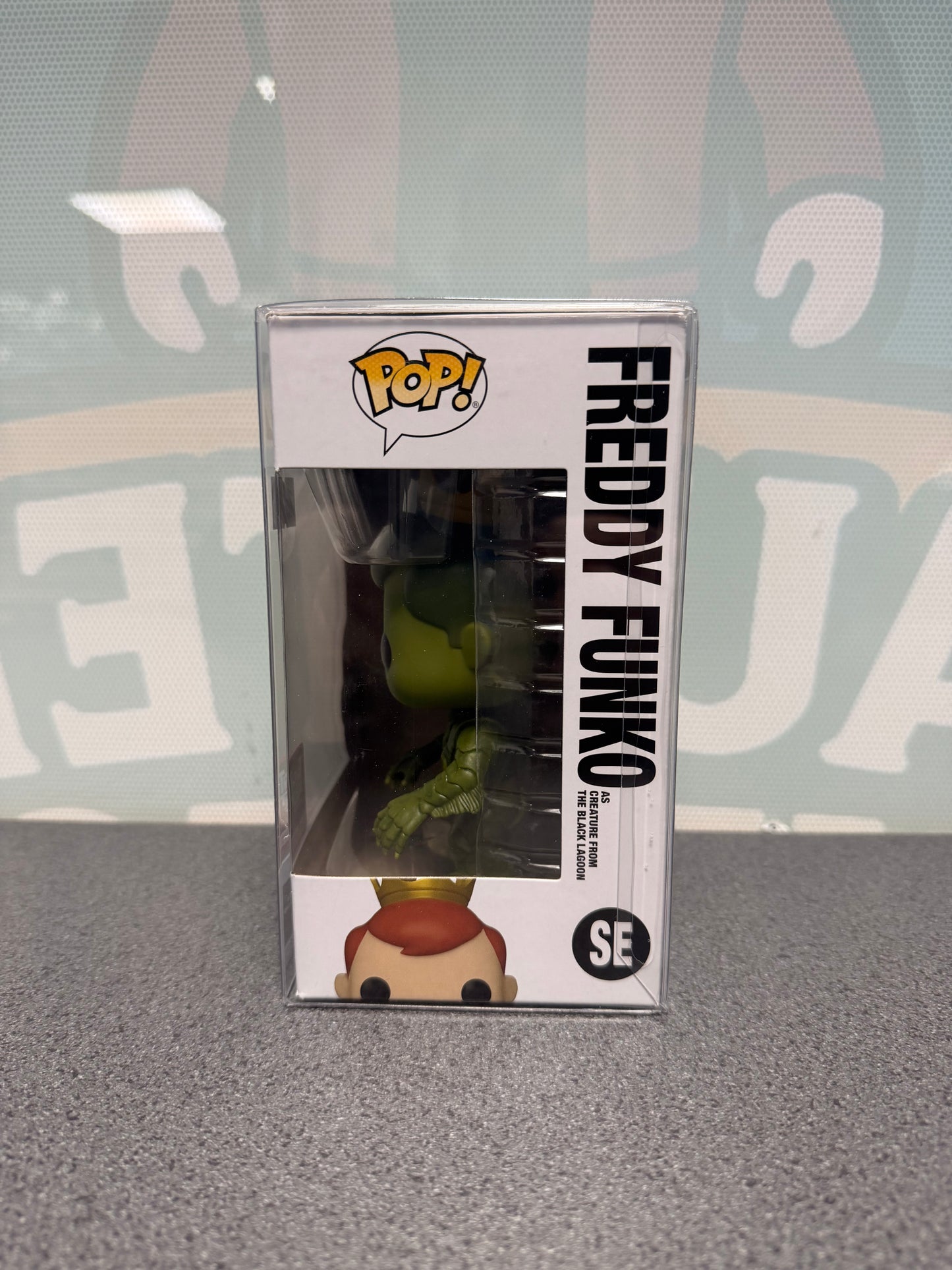 Window side of Freddy Funko as Creature from the Black Lagoon Pop! SE showing the green creature figure.