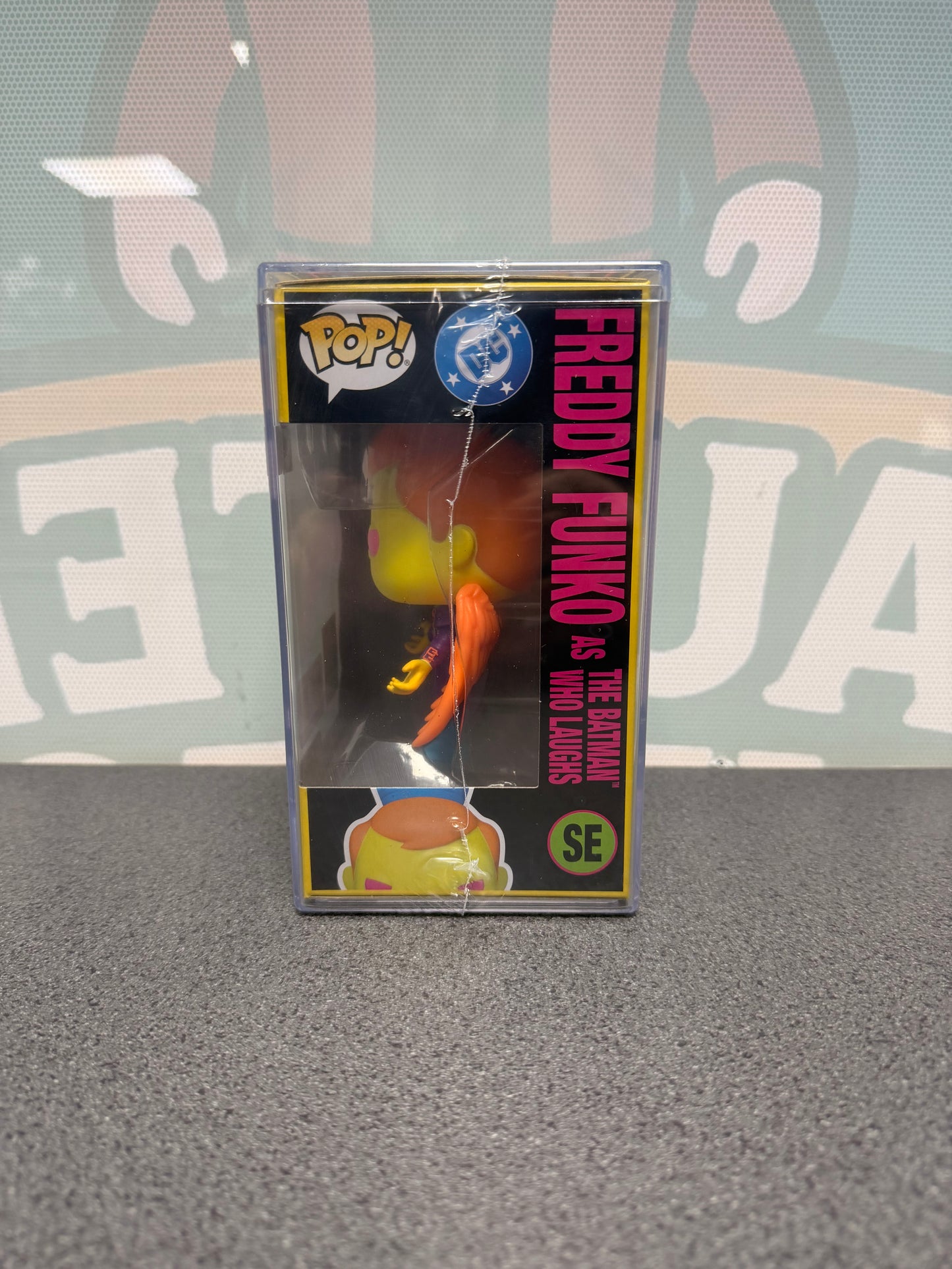 Window side of Freddy Funko as The Batman Who Laughs Blacklight Pop! SE showing the orange wings.